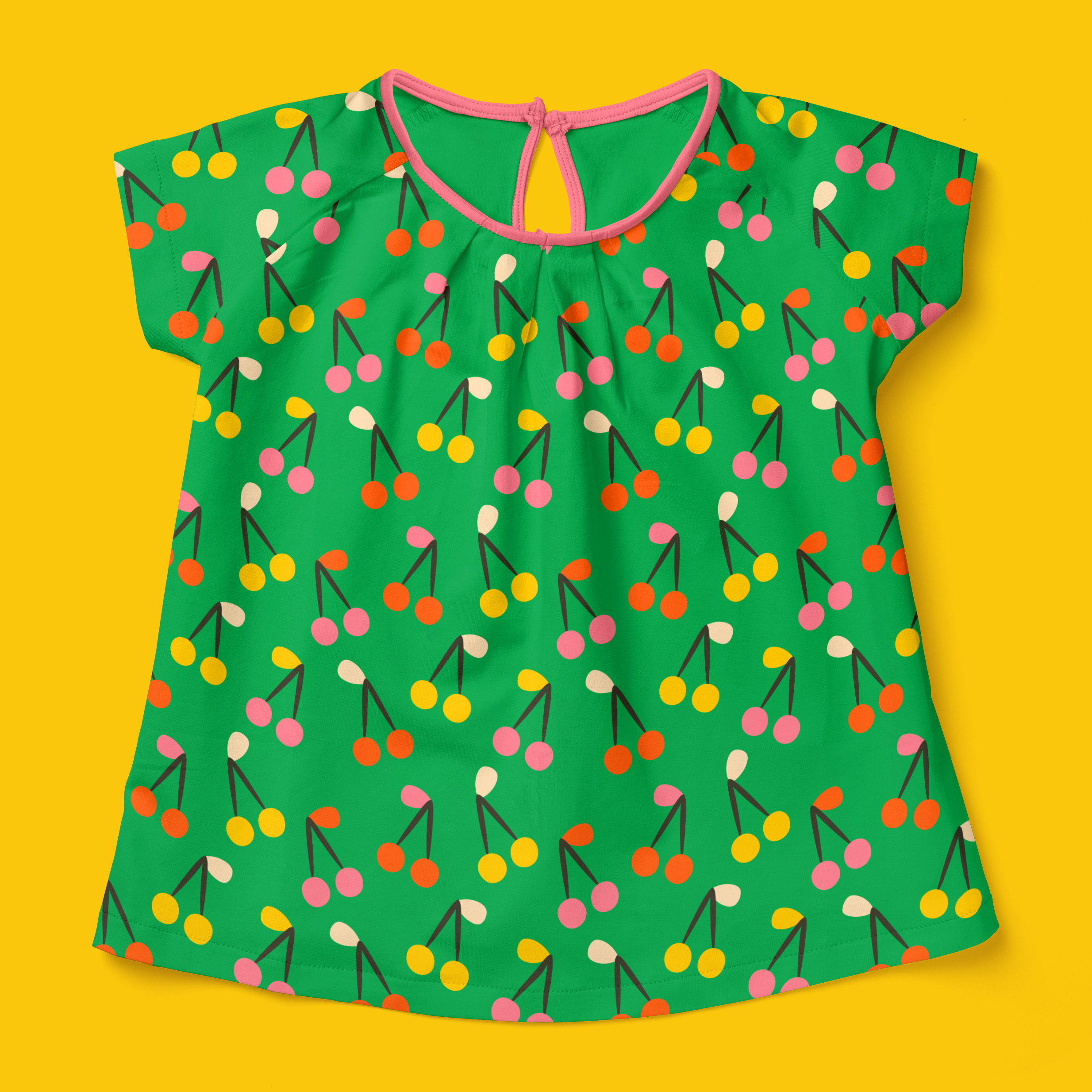 Short-sleeve girls summer t-shirt in bold retro grass green with hand-drawn retro orange, warm yellow and soft pink cherries in pairs with colourful foliage.
The shirt is presented on a bold warm retro yellow background.