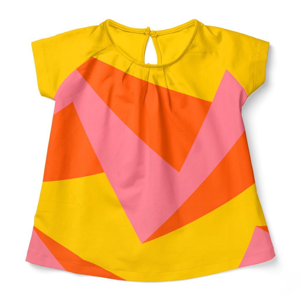 Bold yellow short-sleeve shirt for kids with a bold orange pink 3D zigzag pattern that is scaled much too big for the little shirt.