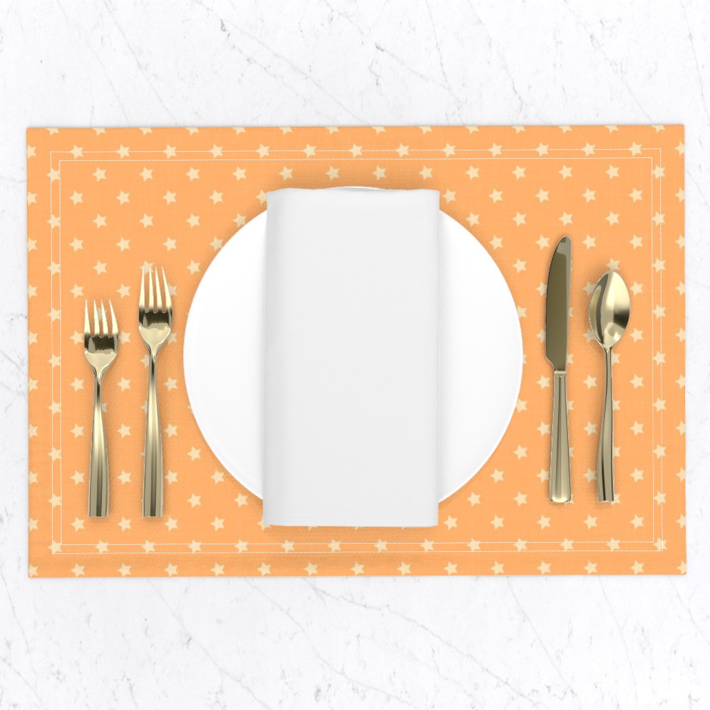 Apricot orange placemat with a small, repeating geometric star pattern in a retro 1950s style, set on a white marble tabletop with gold cutlery and a white plate and napkin.
